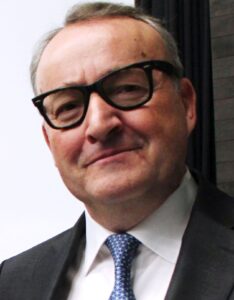 Mann mit Brille in dunklem Anzug