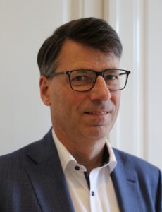 Mann mit Brille in blauem Anzug