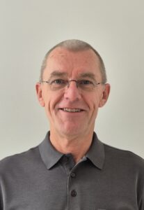 Mann mit Brille in grauem Polo-Hemd
