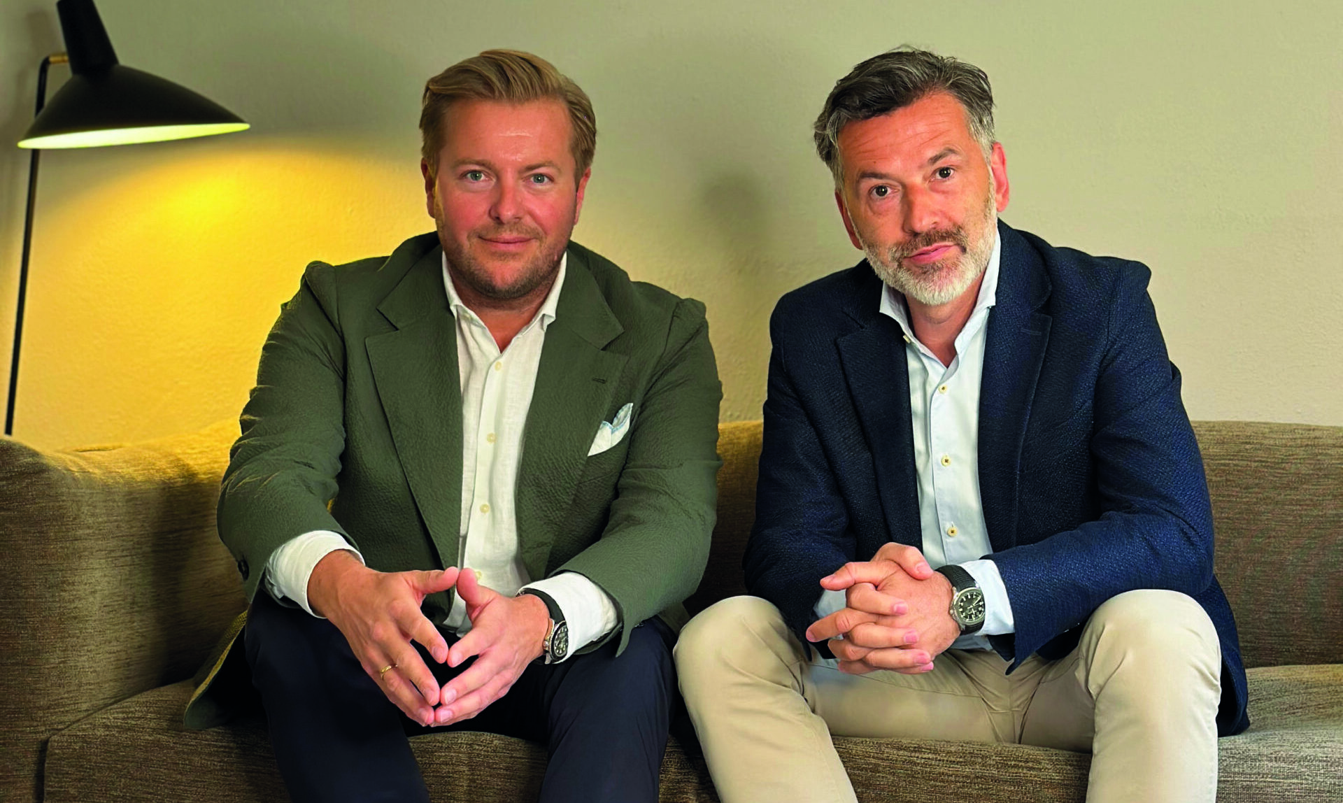 Das neue Duo sitzt auf einer Couch.