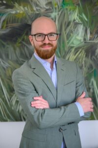 Mann mit Brille in gedeckt-grünem Jackett