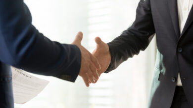 Nahaufnahme der Hände von Geschäftsleuten, die zum Händeschütteln ausgestreckt sind. Geschäftspartner begrüßen sich vor oder nach Vertragsverhandlungen und erzielen einen Konsens bei der Festlegung der Vertragsbedingungen