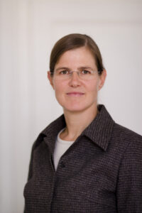 Frau mit Brille in braunem Blazer