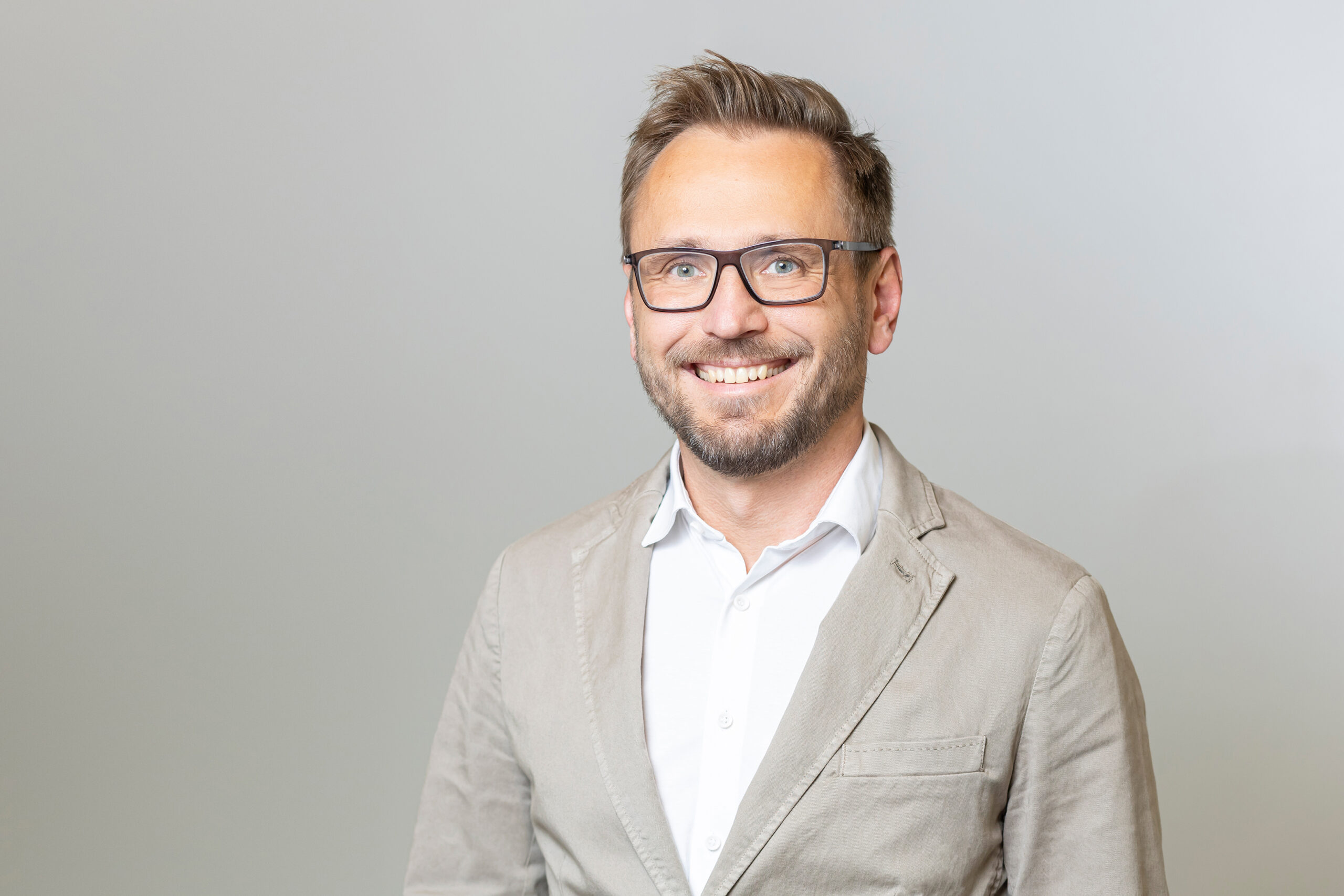 Mann mit Brille in hellbraunem Anzug