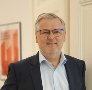 Mann mit Brille in grauem Jackett