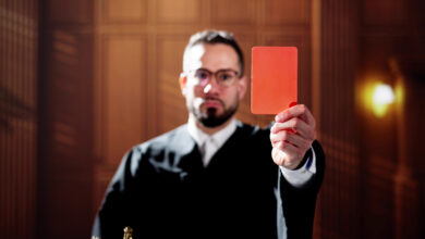 Richter, der eine rote Karte in die Luft hält