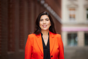 Frau in orangem Blazer