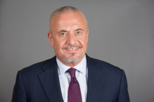 Mann in dunkelblauem Anzug mit dunkelroter Krawatte